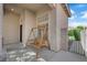 Front porch features a wooden swing, neutral stucco, and views to the front yard and walkway at 21 Rue De Degas, Henderson, NV 89074