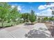 Community recreational area with picnic tables, playground equipment, and shaded spots on concrete slab for outdoor activities at 21 Rue De Degas, Henderson, NV 89074