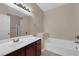 Neutral toned bathroom with a single sink vanity, a framed mirror, and a tub at 2291 W Horizon Ridge Pkwy # 6131, Henderson, NV 89052