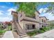 Exterior view of a condo featuring a staircase and landscaped yard under a sunny sky at 2291 W Horizon Ridge Pkwy # 6131, Henderson, NV 89052