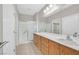 Bright bathroom features a double sink vanity with wood cabinets and a glass enclosed shower at 2428 Hamonah Dr, Henderson, NV 89044