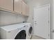 Functional laundry room featuring a side-by-side washer and dryer and overhead cabinet storage space at 2428 Hamonah Dr, Henderson, NV 89044