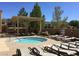 Community pool and hot tub with lounge chairs, tables and shaded pergola at 2428 Hamonah Dr, Henderson, NV 89044