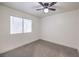 Bright bedroom featuring neutral carpet, ceiling fan, and a large window for natural light at 2501 Muirfield Ave, Henderson, NV 89074