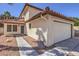 View of the home's front entrance, garage, red tile roof, and low-maintenance desert landscaping at 2501 Muirfield Ave, Henderson, NV 89074