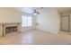 Open living room with a tiled fireplace, bright window and neutral color palette at 2501 Muirfield Ave, Henderson, NV 89074
