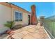 Inviting outdoor patio featuring stone pavers, desert landscaping, and iron fence with golf course views at 2997 Via Meridiana, Henderson, NV 89052