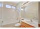 Clean bathroom with a tub and shower, large vanity mirror, and updated fixtures at 3025 Seaford Peak Dr, Henderson, NV 89052