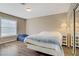 Cozy bedroom with hardwood floors, a large window, and a mirrored sliding closet door at 3420 Lockport St, Las Vegas, NV 89129