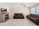 Cozy living room features a brick fireplace, ceiling fan, tile flooring, and comfortable seating at 3715 Tabor Ave, North Las Vegas, NV 89030