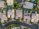 Stunning aerial view of luxury homes, showcasing meticulously manicured landscaping, private pools, and neighborhood street at 38 Moonfire Dr, Las Vegas, NV 89135