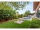 A serene backyard features a pool, spa, built-in barbecue, lush landscaping, and an inviting fire pit at 38 Moonfire Dr, Las Vegas, NV 89135