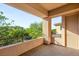 Spacious balcony with tile flooring and railing, offering views of the surrounding trees and neighborhood at 38 Moonfire Dr, Las Vegas, NV 89135