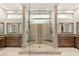 Luxurious bathroom features a spacious glass shower with dual shower heads and stylish wood cabinets at 38 Moonfire Dr, Las Vegas, NV 89135