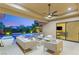 Outdoor patio with a cozy seating area, fire pit, and view of the pool and lush landscaping at 38 Moonfire Dr, Las Vegas, NV 89135