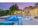 Inviting outdoor pool and spa area with stylish lounge chairs and an outdoor kitchen at 38 Moonfire Dr, Las Vegas, NV 89135
