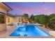 Stunning backyard pool with lounge chairs and landscaped surroundings under a colorful sky at 38 Moonfire Dr, Las Vegas, NV 89135