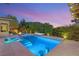 Beautiful backyard pool area with integrated bar stools and lounge seating for entertaining at 38 Moonfire Dr, Las Vegas, NV 89135