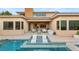 Backyard swimming pool with in-pool lounge chairs, spa, and a covered outdoor seating area at 38 Moonfire Dr, Las Vegas, NV 89135