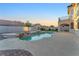 A serene backyard setting features a freeform pool, jacuzzi, and lush desert landscaping at 387 Hoskins Ct, Henderson, NV 89012