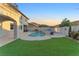 Beautiful backyard featuring an in-ground pool, artificial grass, and view of the two-story home at 387 Hoskins Ct, Henderson, NV 89012