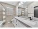Modern bathroom featuring a double vanity with white cabinets, a large mirror, and a shower-tub combo at 387 Hoskins Ct, Henderson, NV 89012