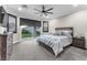 Comfortable bedroom featuring a ceiling fan, a sliding glass door and gray patterned carpet at 387 Hoskins Ct, Henderson, NV 89012