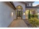 Close up of the entryway gate with desert landscaping, and covered porch with exterior lighting at 387 Hoskins Ct, Henderson, NV 89012