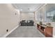 Well-lit living room features neutral walls, light grey tile flooring, and comfortable seating beneath bright windows at 387 Hoskins Ct, Henderson, NV 89012