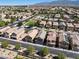 Nice aerial of a residential neighborhood featuring uniform homes and community green spaces, with mountain views at 4351 Hera Temple Ave, North Las Vegas, NV 89031
