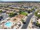 Expansive aerial view of a community featuring a pool, playground, and green spaces amidst neatly arranged homes at 4351 Hera Temple Ave, North Las Vegas, NV 89031