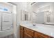 Bright bathroom featuring a shower-tub combo, wood vanity and large mirror at 4351 Hera Temple Ave, North Las Vegas, NV 89031