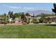 A well-maintained community playground with lush green grass and mature landscaping, set against a backdrop of desert mountains at 4351 Hera Temple Ave, North Las Vegas, NV 89031