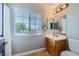 Well-lit bathroom featuring a wood vanity, a large window with blinds, and neutral decor at 4361 Valley Quail Way, North Las Vegas, NV 89084