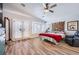Cozy bedroom featuring wood floors, ceiling fan, and double doors to the exterior at 4361 Valley Quail Way, North Las Vegas, NV 89084