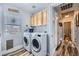 Well-lit laundry room featuring a modern washer and dryer and wood look floors at 4361 Valley Quail Way, North Las Vegas, NV 89084