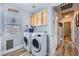 Laundry room featuring front load washer and dryer, cabinets and a window at 4361 Valley Quail Way, North Las Vegas, NV 89084