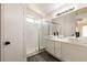 Modern bathroom featuring double sinks, a walk-in shower with glass doors, and contemporary lighting at 4825 White Aspen Ave, Las Vegas, NV 89130