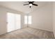 Spacious bedroom with large windows, plush carpeting, and a ceiling fan at 4825 White Aspen Ave, Las Vegas, NV 89130