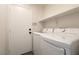 Functional laundry area with washer, dryer, and a shelf for storage solutions at 4825 White Aspen Ave, Las Vegas, NV 89130