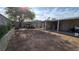Spacious backyard featuring a covered patio, ample gardening space, and mature trees at 5209 Del Monte Ave, Las Vegas, NV 89146