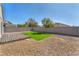 This backyard offers a small, wooden deck, a patch of lawn, and rock landscaping at 5912 Kentlands St, Las Vegas, NV 89130