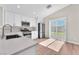 Bright kitchen with stainless steel appliances, stone countertops, and sliding glass doors to the backyard at 5912 Kentlands St, Las Vegas, NV 89130