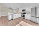 Kitchen featuring white cabinets and stainless steel appliances; open concept living and dining area at 5912 Kentlands St, Las Vegas, NV 89130