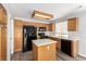Well-equipped kitchen featuring wooden cabinetry, black appliances, and a center island, offering practicality at 6112 Grape Blossom Ave, Las Vegas, NV 89142