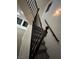 Classic staircase with dark wood railings, carpeted steps, and a charming window accenting the ascent at 6412 Point Break St, North Las Vegas, NV 89084