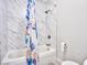 Bathroom with a tub, marble tiling, shower, and a toilet with patterned shower curtain at 6848 Groveview Ln, Las Vegas, NV 89103