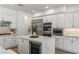 Well-equipped kitchen with stainless appliances, white cabinetry, stone countertops, and ample storage space at 712 Proud Eagle Ln, Las Vegas, NV 89144