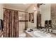 Stylish bathroom with a shower and tub combo, decorative mirror, and ample counter space at 7201 Mission Hills Dr, Las Vegas, NV 89113