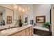 Bright bathroom featuring double sinks, a soaking tub, and modern lighting fixtures at 7201 Mission Hills Dr, Las Vegas, NV 89113